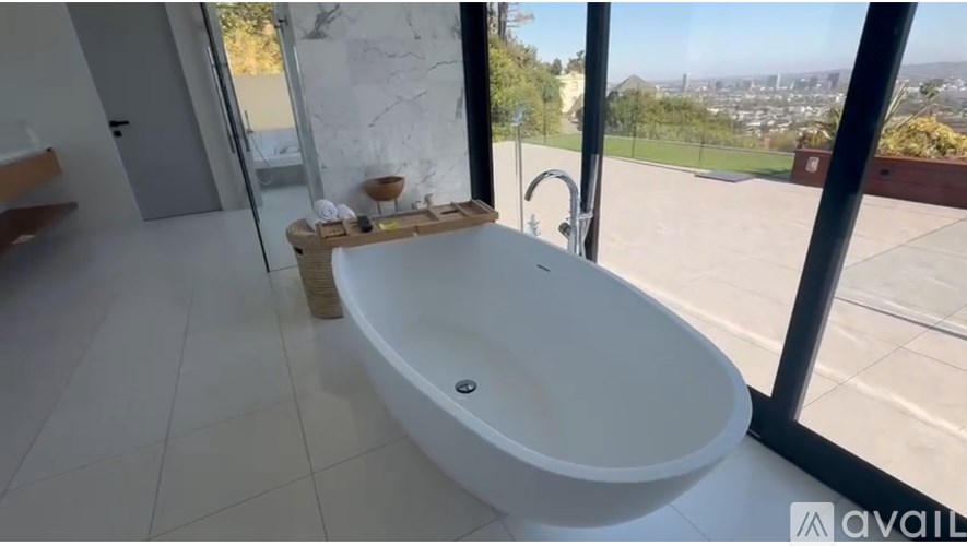 A white bathroom sink with a view of the city.