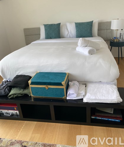 A bed with white sheets and a white pillow with a white towel on it.