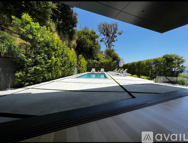 A pool surrounded by trees and a building.