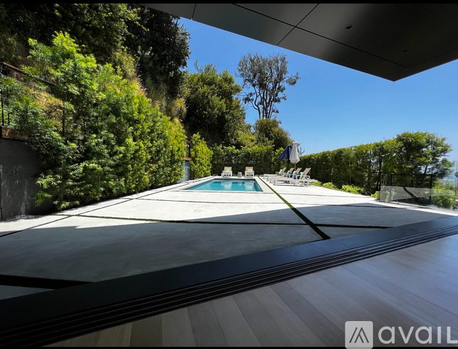 A pool surrounded by trees and a building.