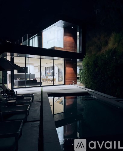 A modern house with a pool at night.