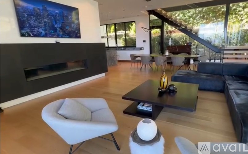 A modern living room with a fireplace and a painting on the wall.