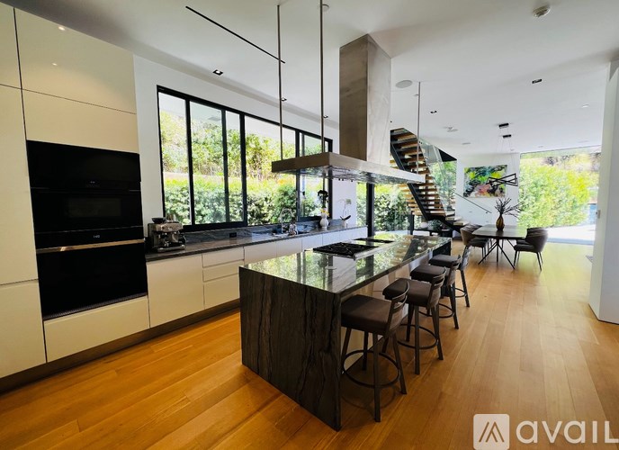 A modern kitchen with a bar area and a staircase.