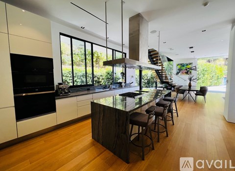 A modern kitchen with a bar area and a staircase.