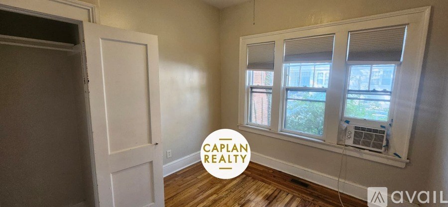 A room with a window and a door is available for rent.