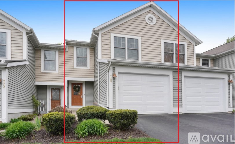 A house with a brown door and two garages.