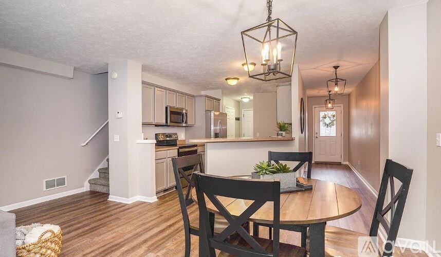 A dining room with a wooden table and chairs.