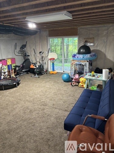 A room with a blue couch and exercise equipment.