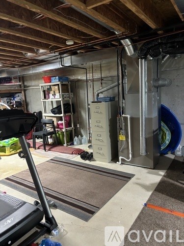 A room with a lot of pipes and a treadmill.