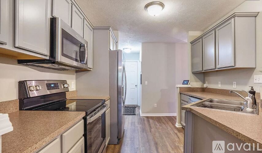 A kitchen with a white refrigerator and a microwave above the stove.