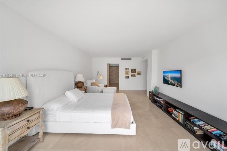 A bedroom with a large bed and a TV on the wall.