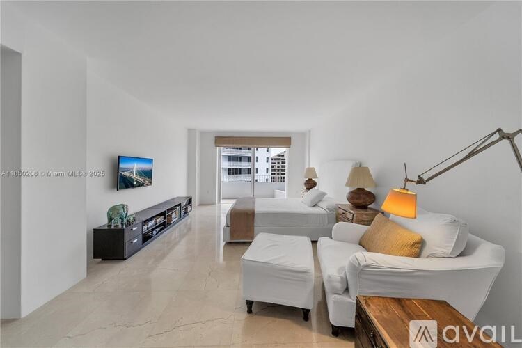 A living room with a white couch and a painting on the wall.