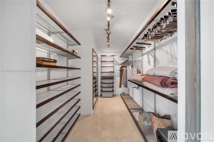 A walk-in closet with shelves and clothes.