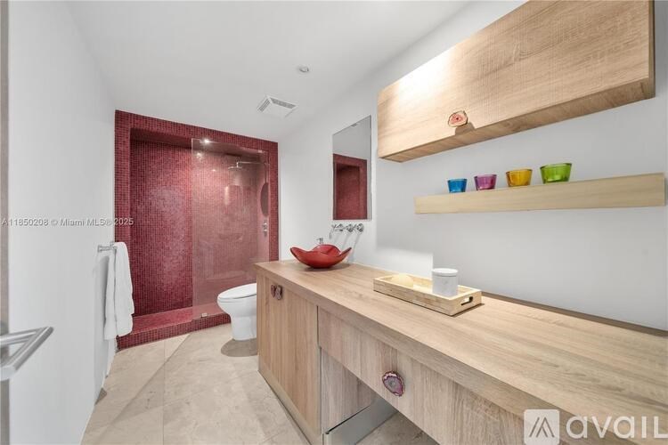 A bathroom with a wooden vanity and a red tiled shower.
