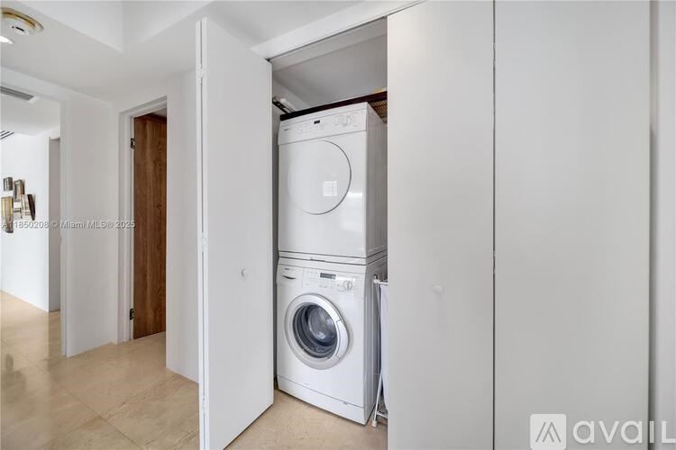 A modern laundry room with a washer and dryer built into the wall.
