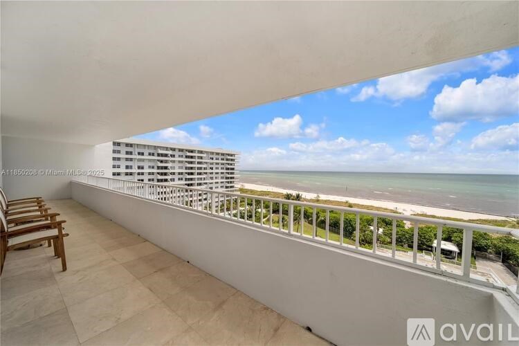 A balcony with a view of the ocean and a building in the distance.