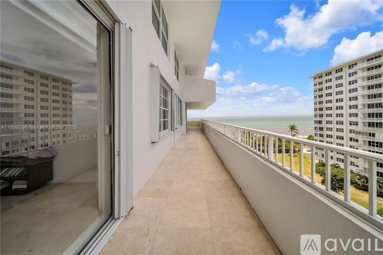A balcony with a view of a building and trees.