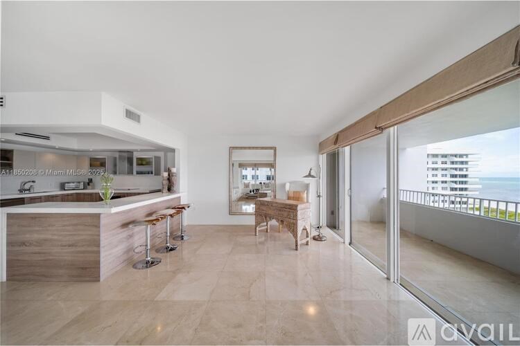 A modern kitchen with a bar area and a view of the city.