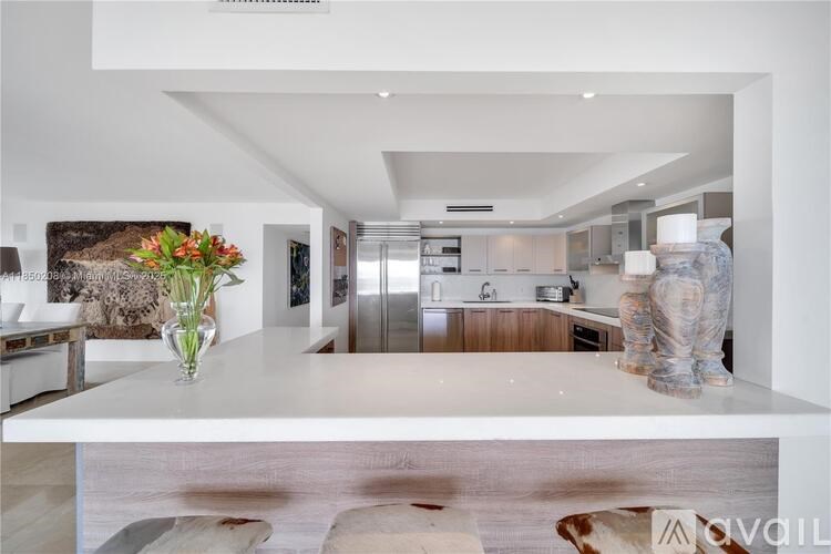 A modern kitchen with a white countertop and a cowhide rug on the floor.