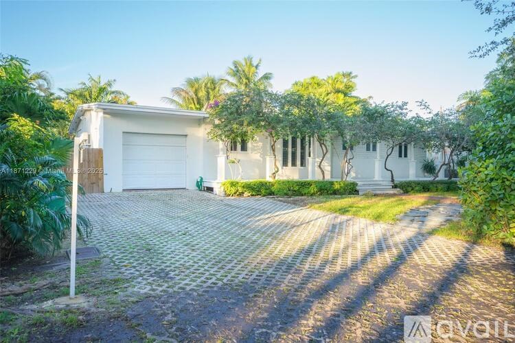 A white house with a driveway in front of it.