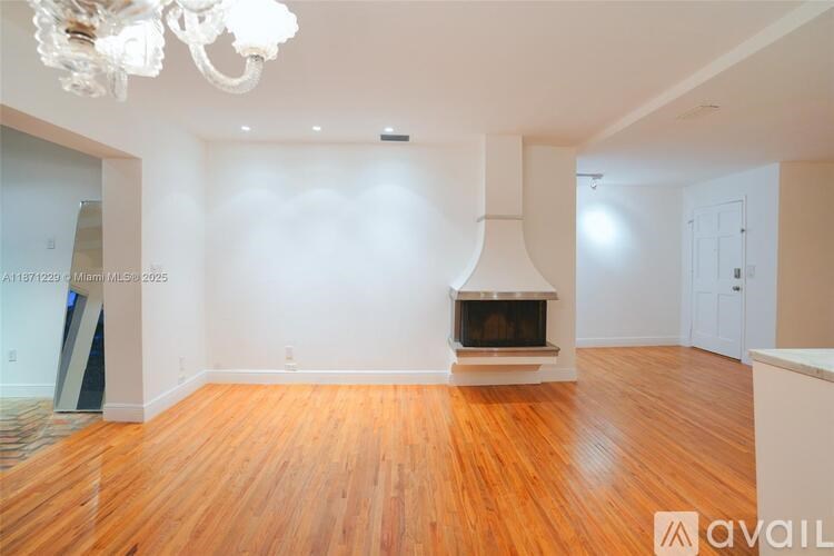 A living room with a fireplace and a chandelier.