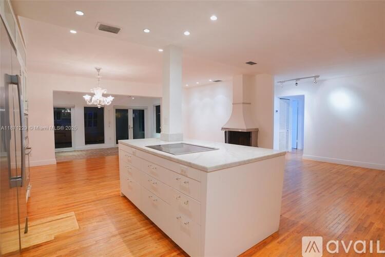 A spacious kitchen with wooden floors and a central island.