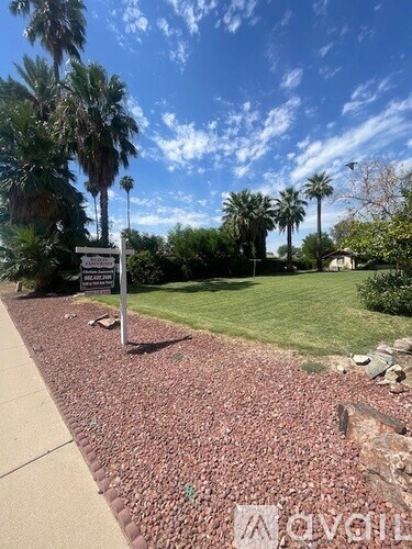 A sign is standing in a field of red gravel.
