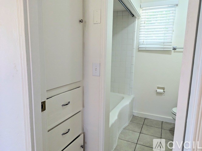 A bathroom with a white tub and a white door.