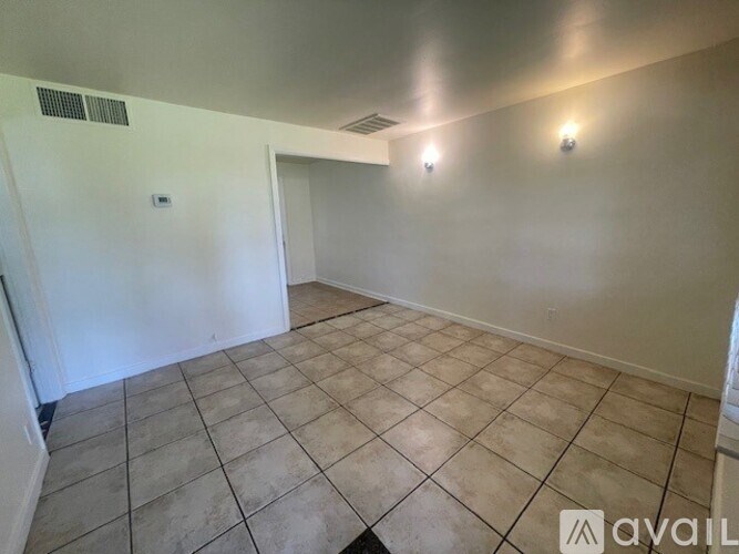 A room with beige tiled flooring and white walls.