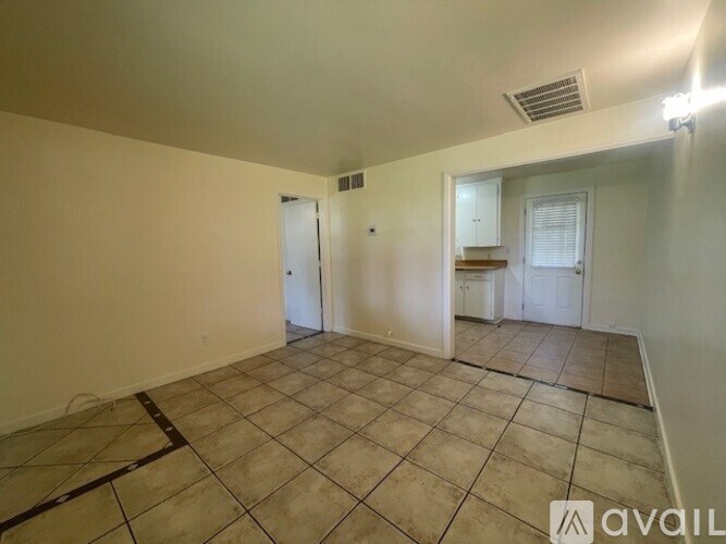 A room with tiled flooring and a door on the left.