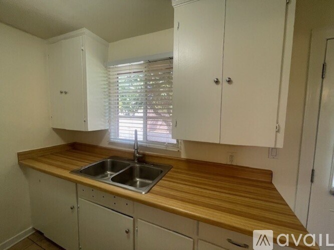 A kitchen with white cabinets and a wooden countertop.