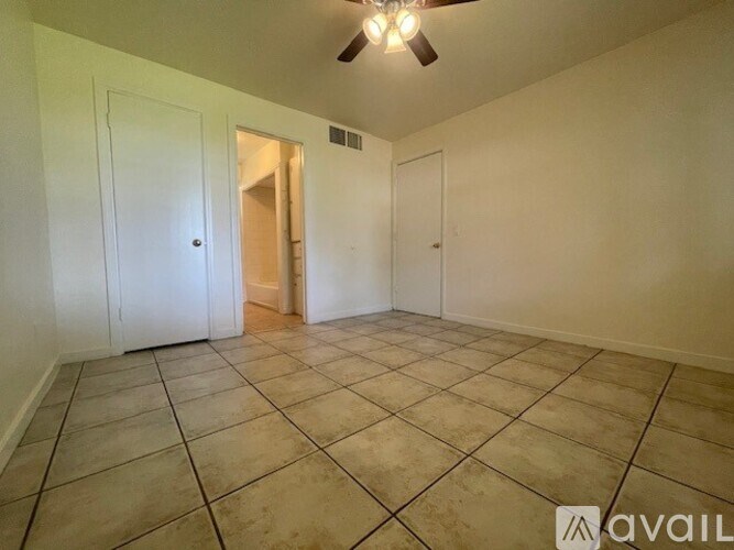 A room with a ceiling fan and tile flooring.