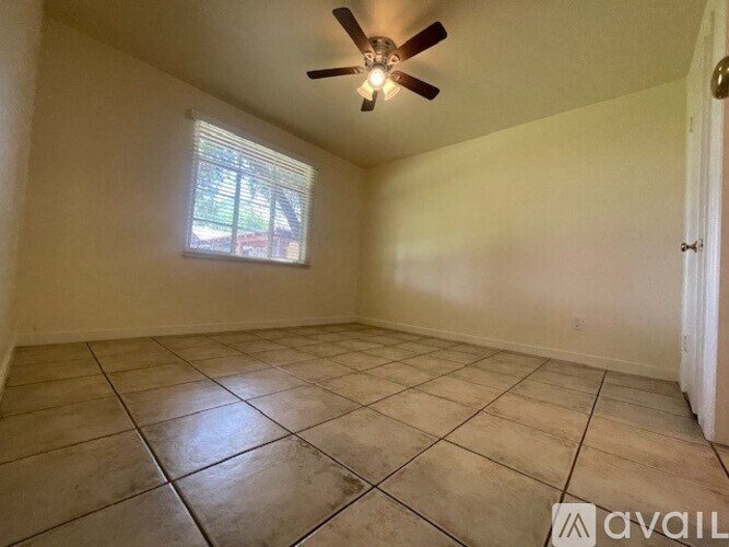 Empty room with tiled floor and ceiling fan.