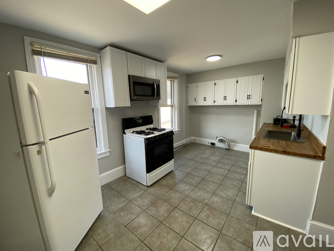 A kitchen with white cabinets and a black stove top.