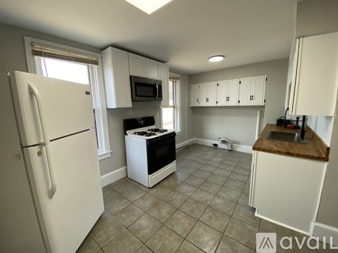 A kitchen with white cabinets and a black stove top.