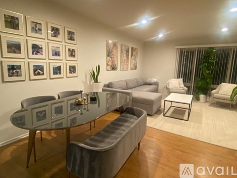 A living room with a glass table and grey couches.