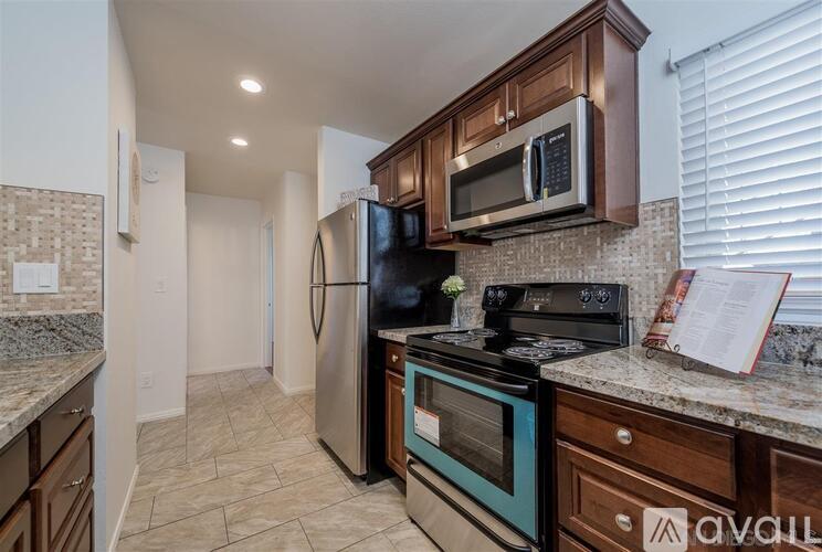 A kitchen with a refrigerator, oven, and microwave.