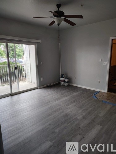 A room with a ceiling fan and a sliding glass door.
