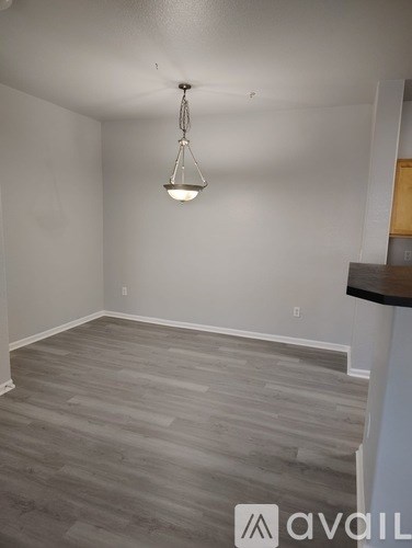 A room with a wooden floor and a hanging light fixture.