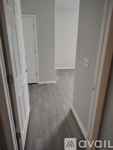 A hallway with a white door and a grey floor.