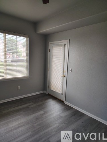 A room with a door and a window with blinds.