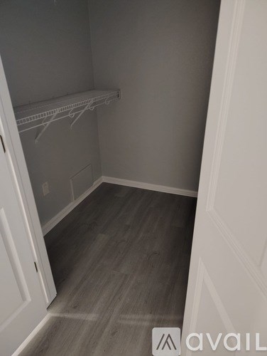A small, empty room with a white door and a shelf.