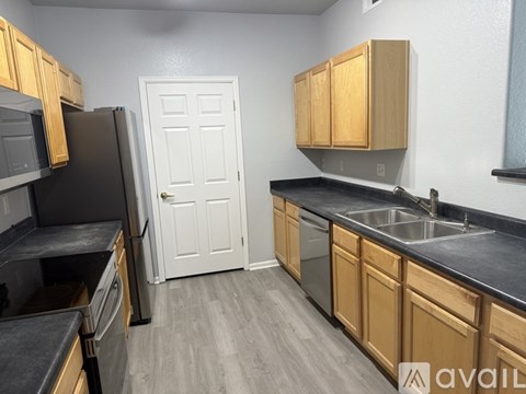 A kitchen with wooden cabinets and a black countertop.