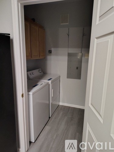 A small kitchen with a black fridge, white oven and a white dishwasher.