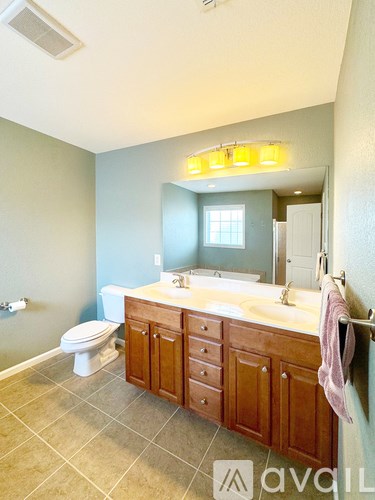 A bathroom with a toilet, sink, and mirror.