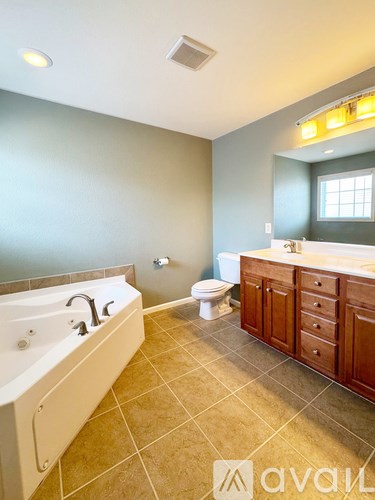 A bathroom with a tub, toilet, and sink.