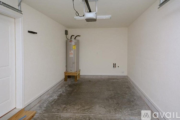 A room with a white wall and a concrete floor.
