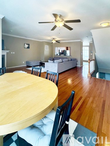 A living room with a couch, a table, and a ceiling fan.