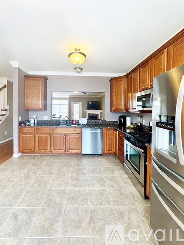 A kitchen with wooden cabinets and black countertops.