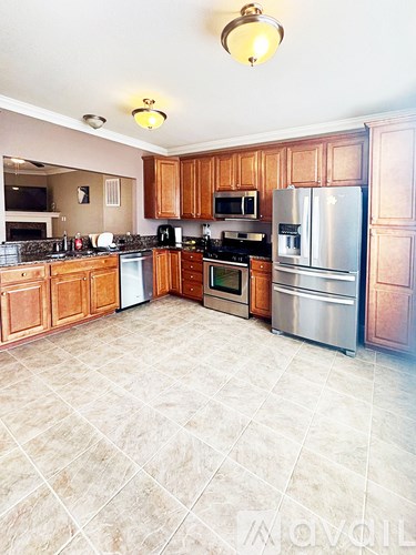 A kitchen with wooden cabinets and tile flooring.
